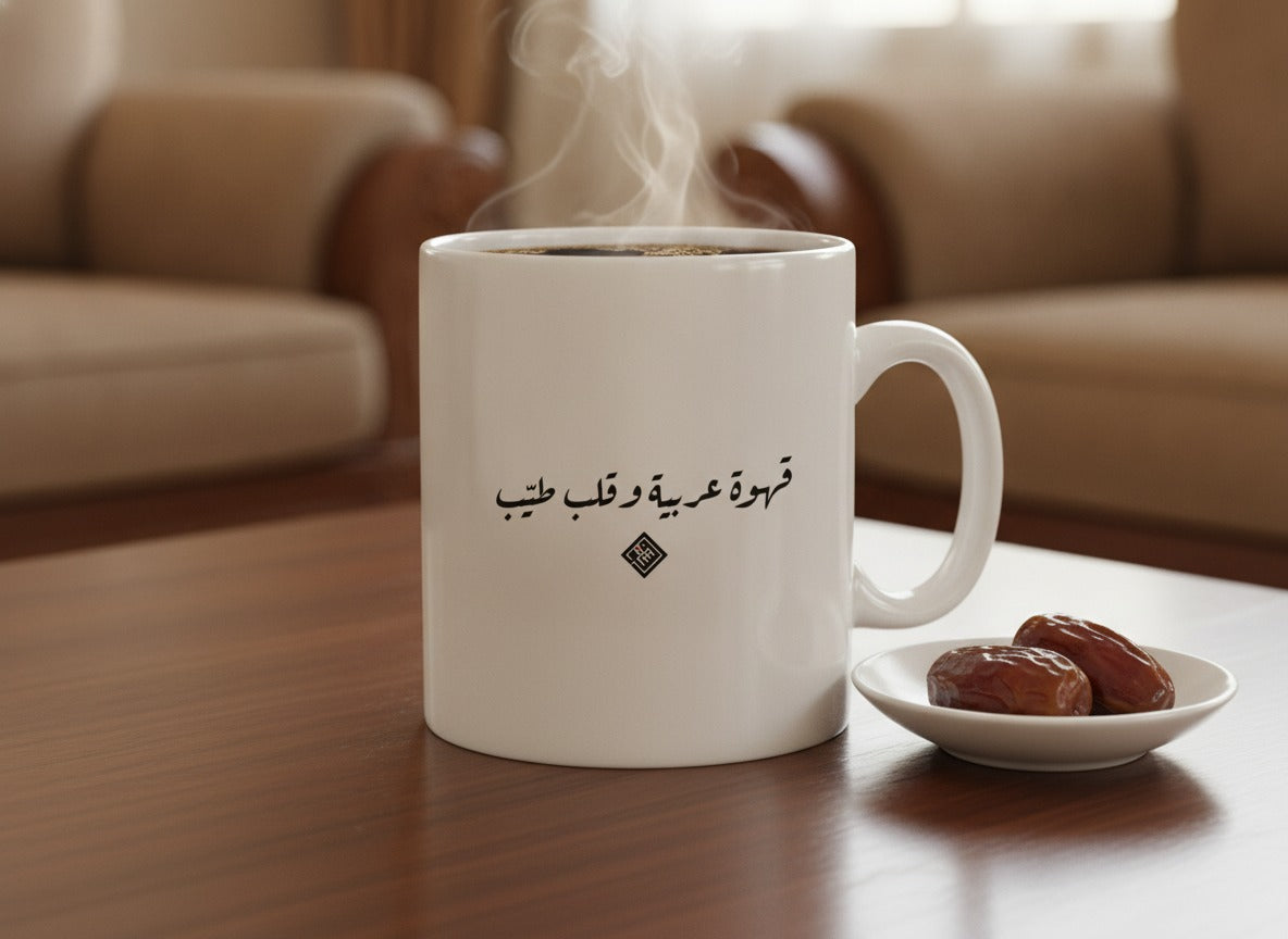 «قهوة عربية وقلب طيّب» in Ruq'ah printed on a ceramic mug, photographed on a table