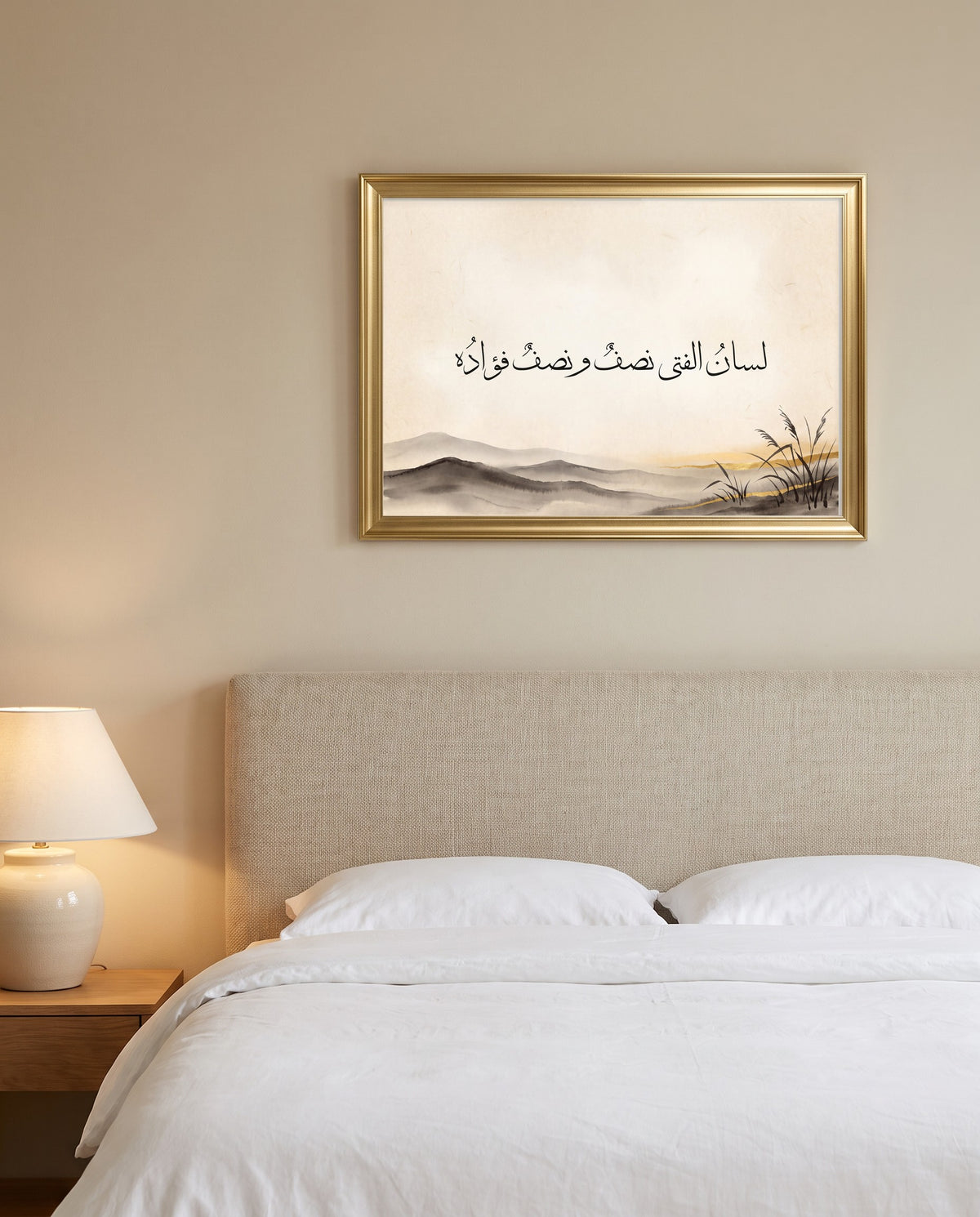 A Person Is Half Tongue, Half Heart: Arabic poetry in Thuluth calligraphy, framed in polished gold above a bed with white linen