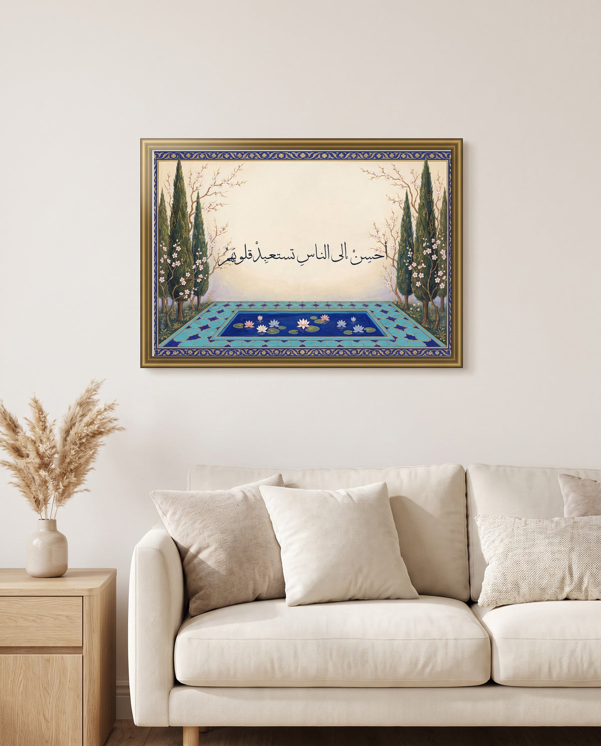 Be Good to People and Win Their Hearts: Arabic poetry in Thuluth calligraphy, framed in polished gold above a cream sofa in a living room