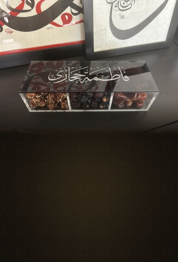A personalised acrylic dates box with «فاطمة حجازي» engraved on the lid in Thuluth