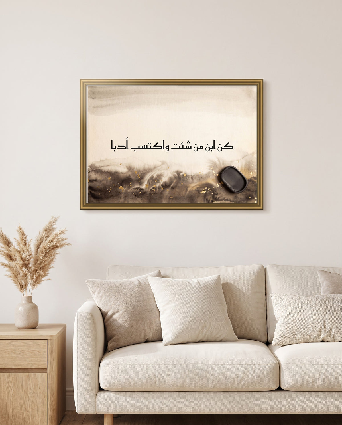 Be Anyone’s Son, but Earn Good Manners: Arabic poetry in Kufic calligraphy, framed in polished gold above a cream sofa in a living room