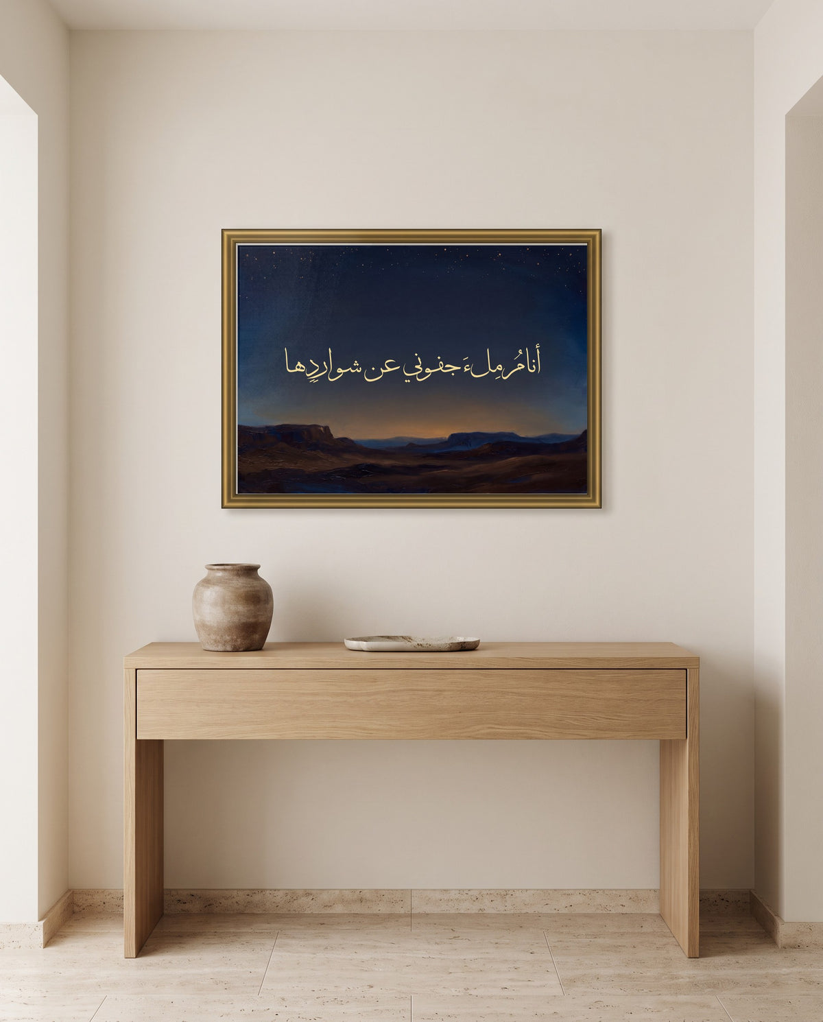 I Sleep Soundly While Others Argue: Arabic poetry in Thuluth calligraphy, framed in polished gold above an oak console in an entrance hall