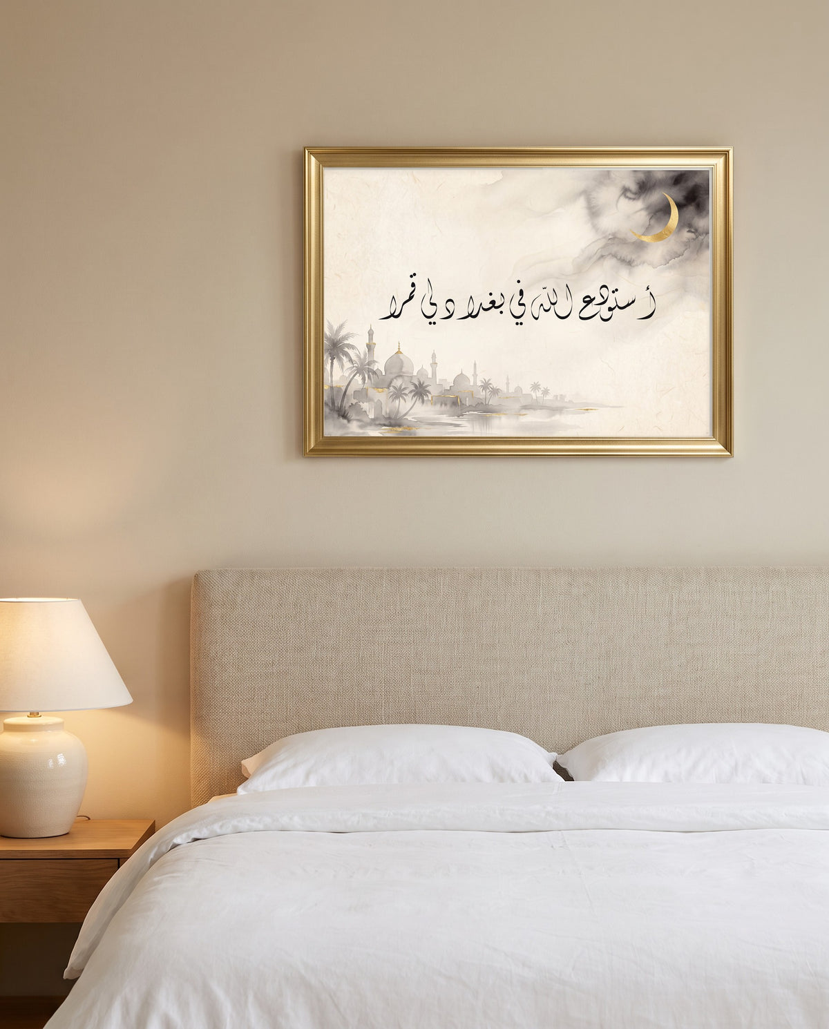 A Moon I Leave in God’s Keeping in Baghdad: Arabic poetry in Diwani calligraphy, framed in polished gold above a bed with white linen