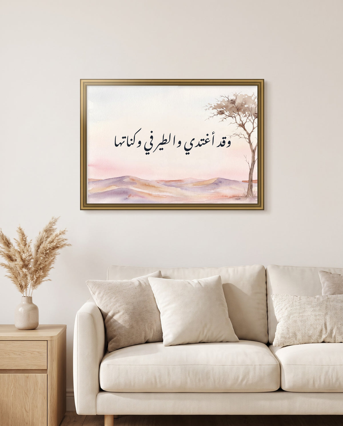 I Ride Out at Dawn, the Birds Still in Their Nests: Arabic poetry in Nastaliq calligraphy, framed in polished gold above a cream sofa in a living room