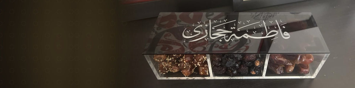 A personalised acrylic dates box with «فاطمة حجازي» engraved on the lid in Thuluth