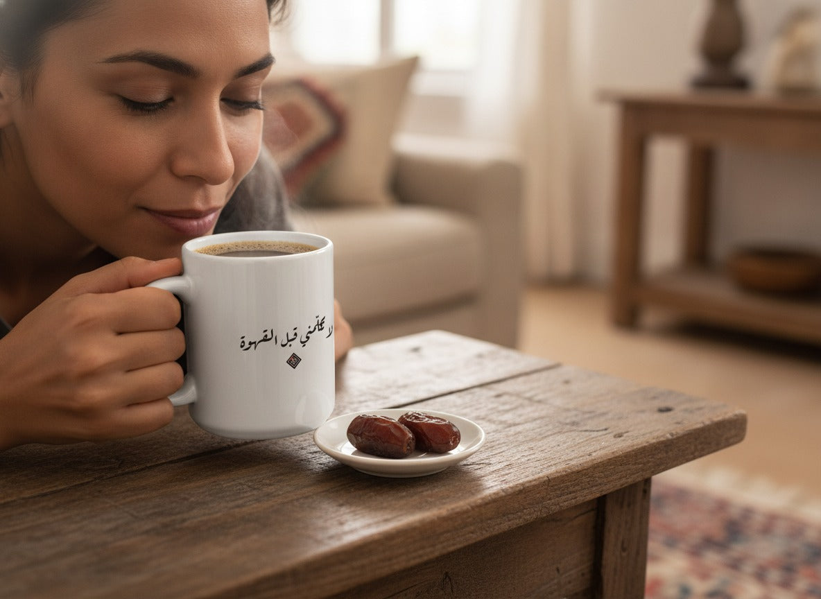 «لا تكلّمني قبل القهوة» calligraphy mug in hand, mid-sip