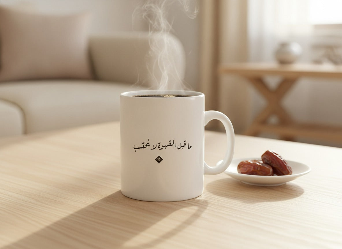 «ما قبل القهوة لا يُحتسب» calligraphy mug, filled, on a coffee table