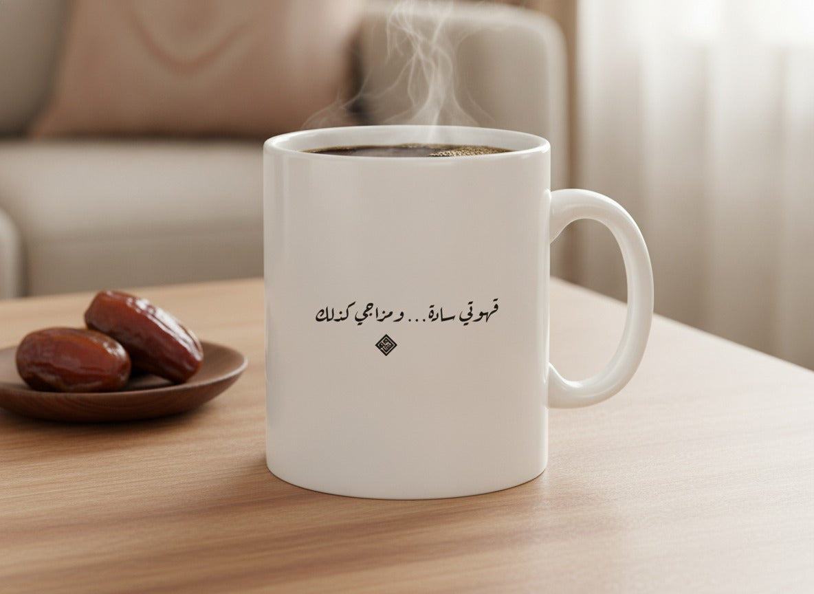 «قهوتي سادة… ومزاجي كذلك» calligraphy mug, filled, on a coffee table