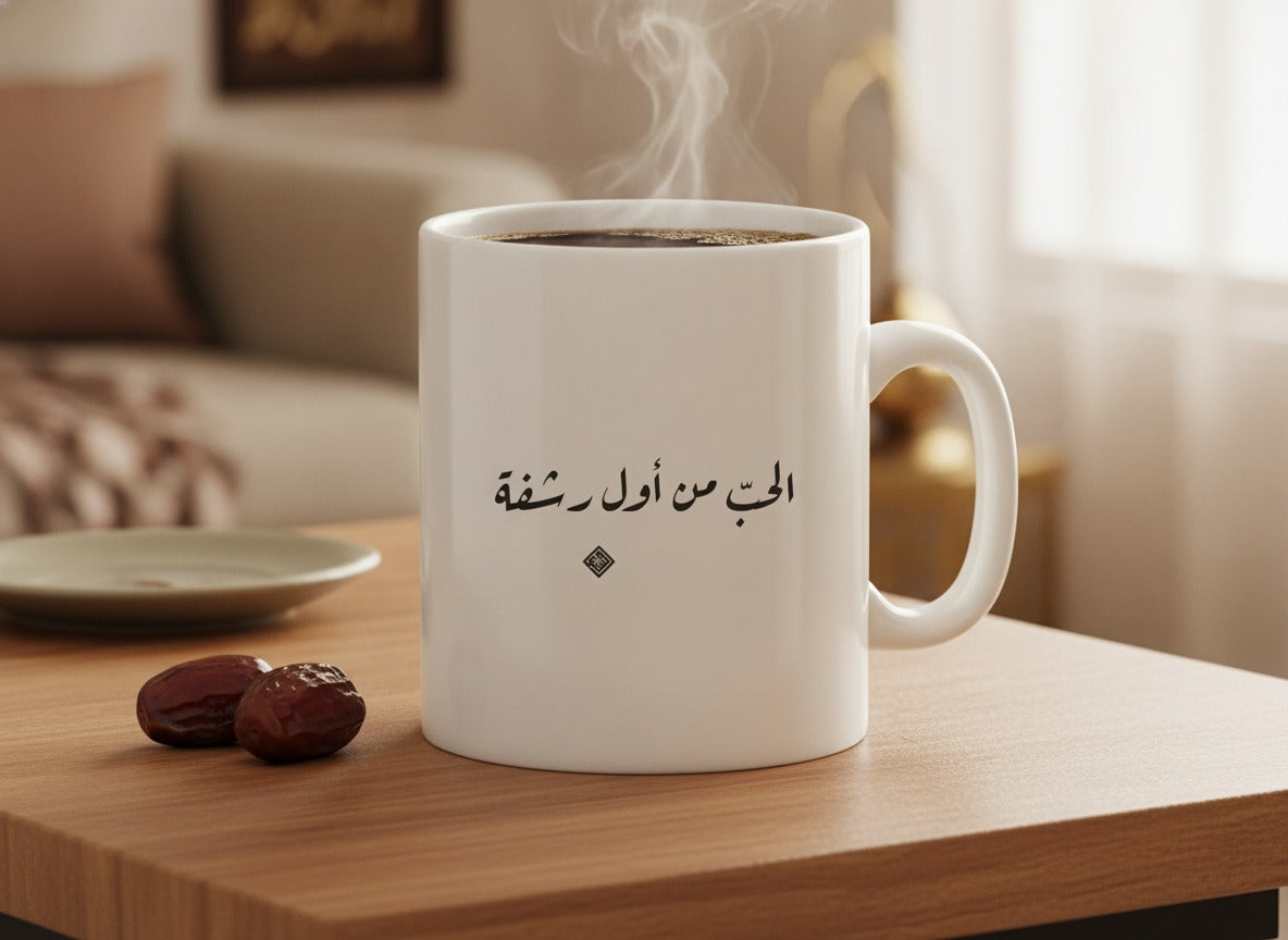 «الحبّ من أول رشفة» calligraphy mug, filled, on a coffee table